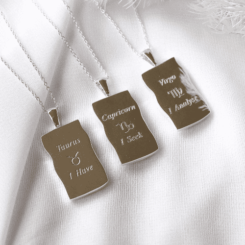 Image shows the back of zodiac necklaces in silver in Taurus, Capricorn and Virgo variants